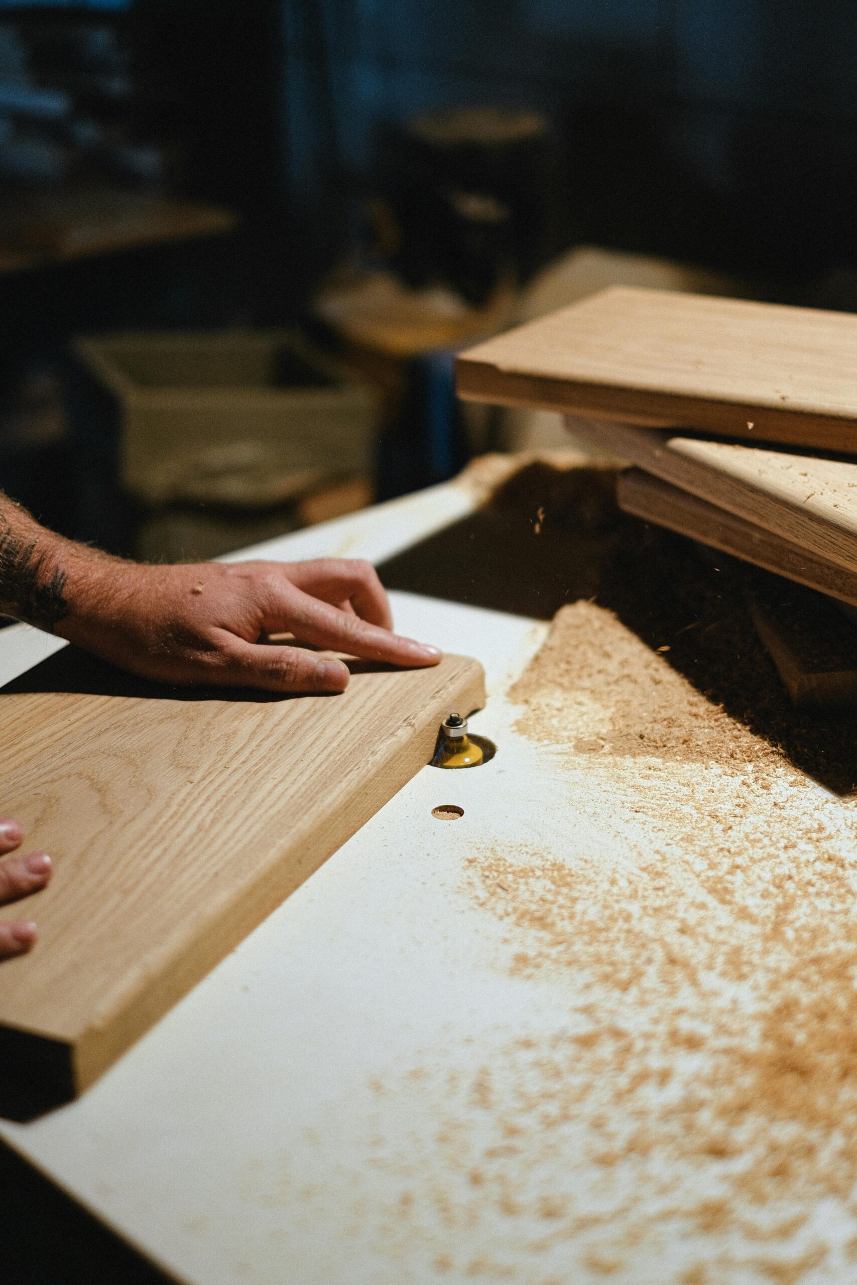 A skilled craftsman shapes a wood plank in a workshop, showcasing carpentry expertise.